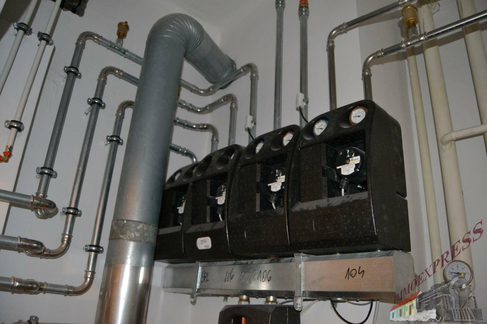 Technikraum mit mehreren Zählern und umfangreicher Rohrinstallation, ordentlich und funktional.