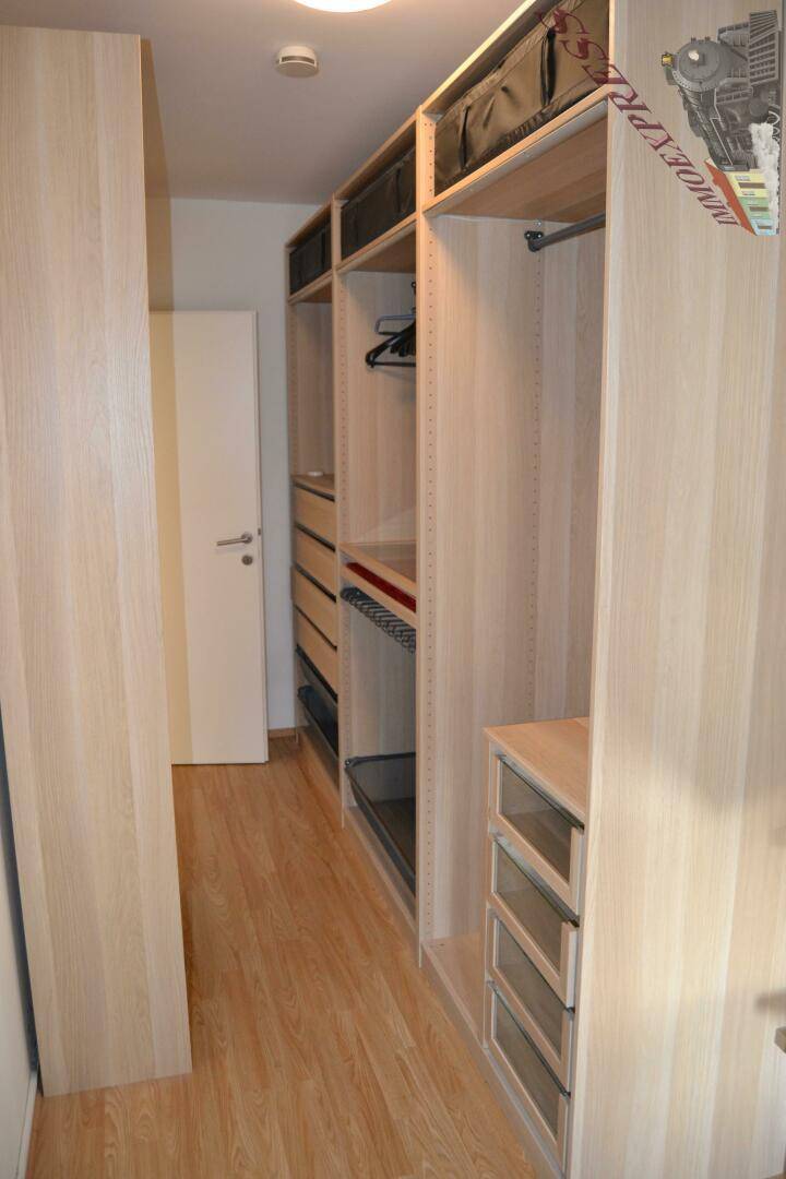 Heller begehbarer Kleiderschrank mit offenen Regalen und Schubladen für optimale Organisation.