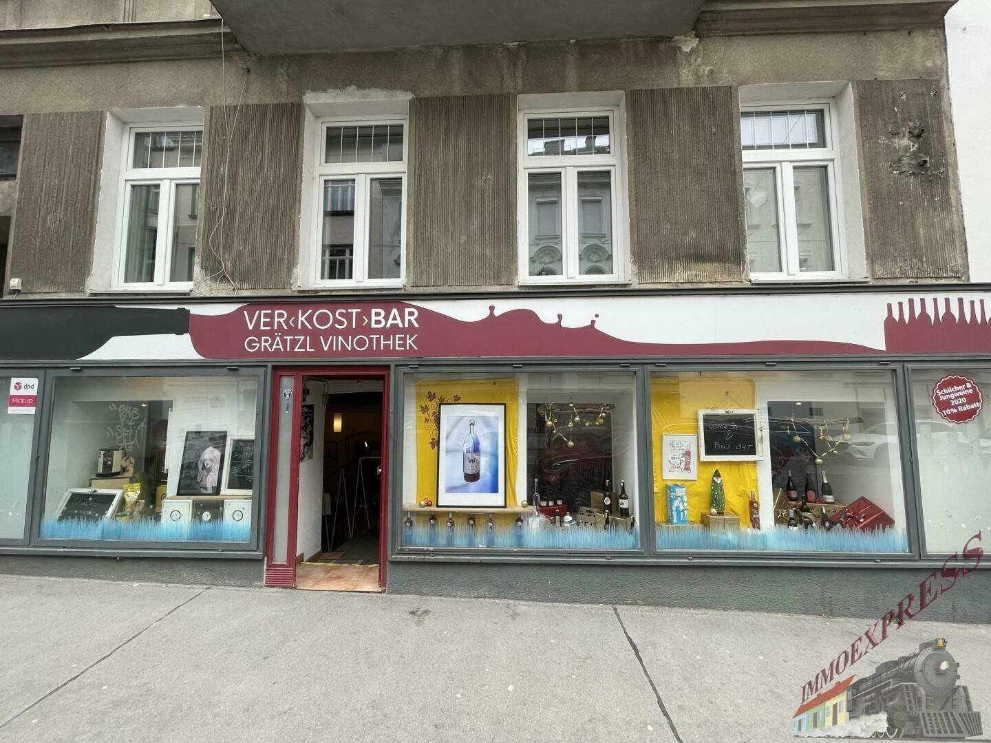 Ansicht der Geschäftsfassade mit breiten Schaufenstern und dem Eingangsbereich von der Straße aus.