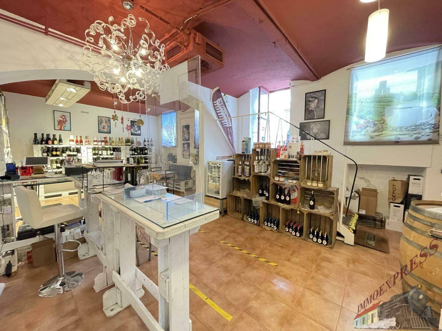 Verkaufsbereich mit Theke, Barhocker, Produktregalen und einer auffälligen Deckenleuchte.
