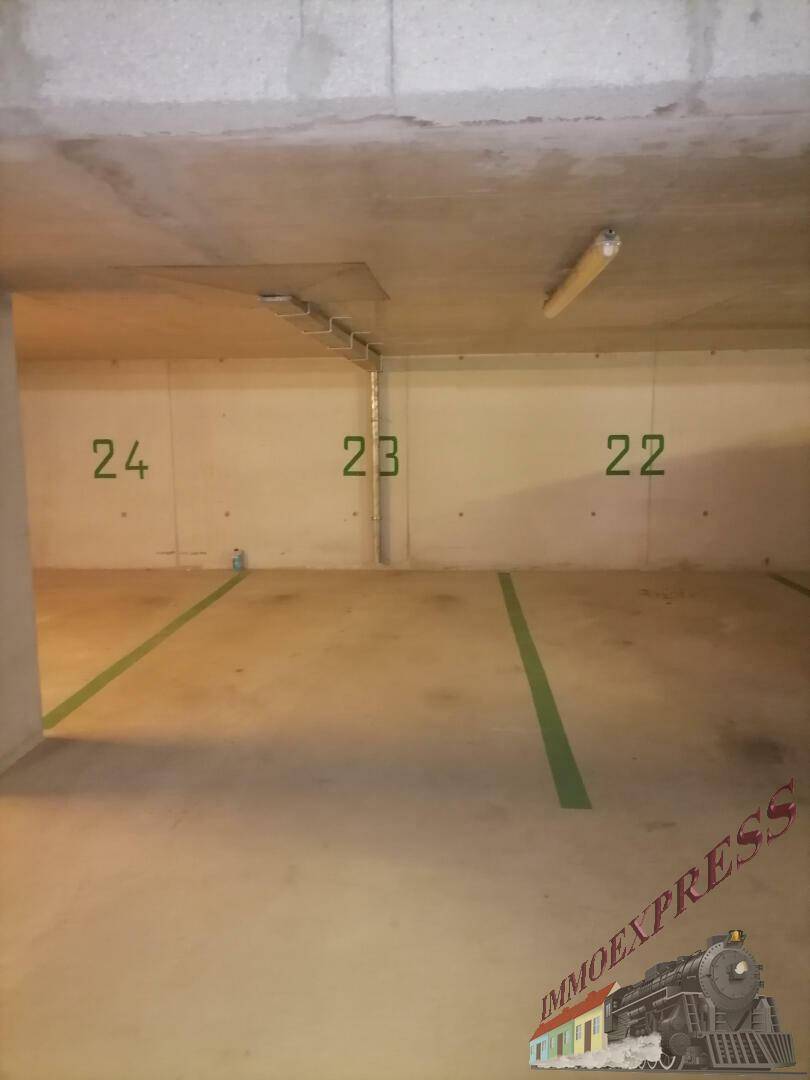 Tiefgarage mit nummerierten Stellplätzen und Betonwänden.