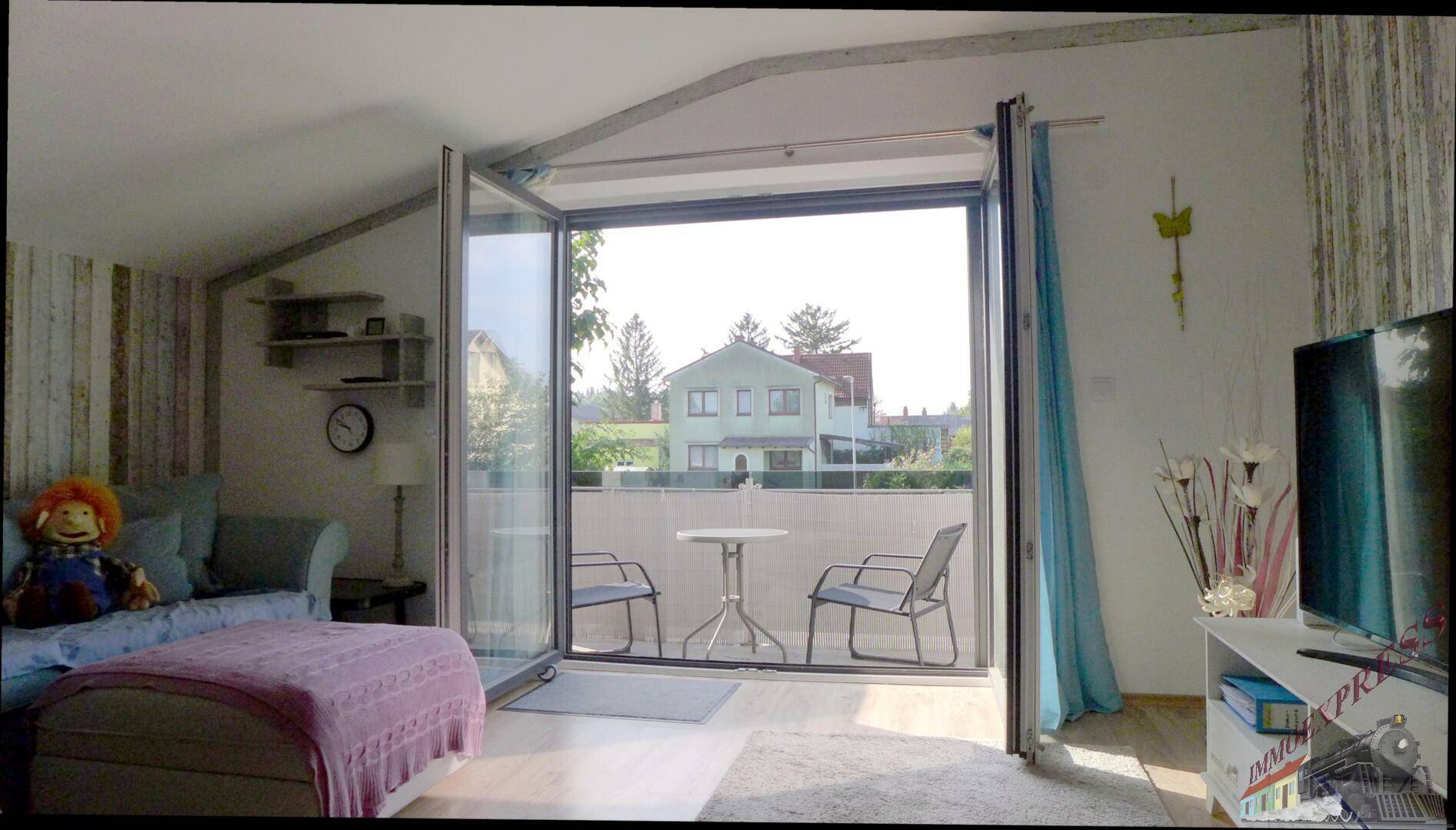 Heller Wohnbereich mit Zugang zum Balkon, Blick ins Grüne und viel Tageslicht.