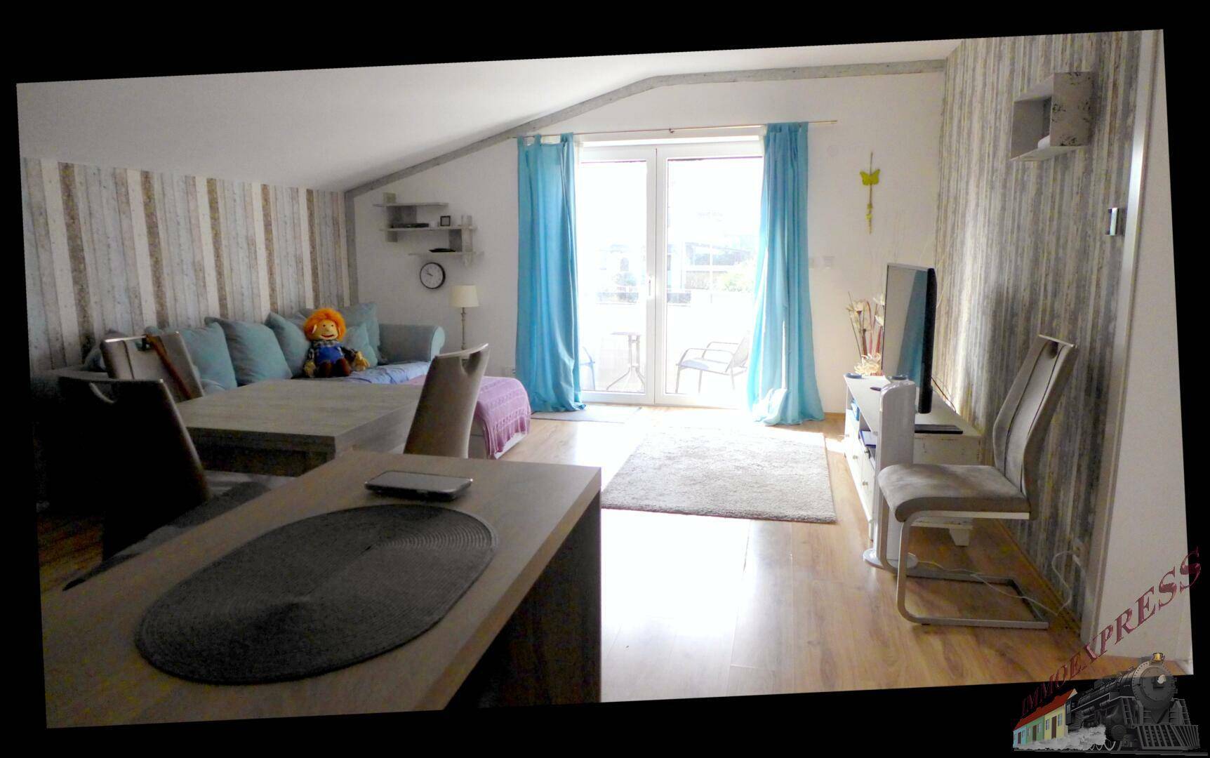 Geräumiger Wohn- und Essbereich mit Holzboden, Sofa und direktem Balkonzugang.