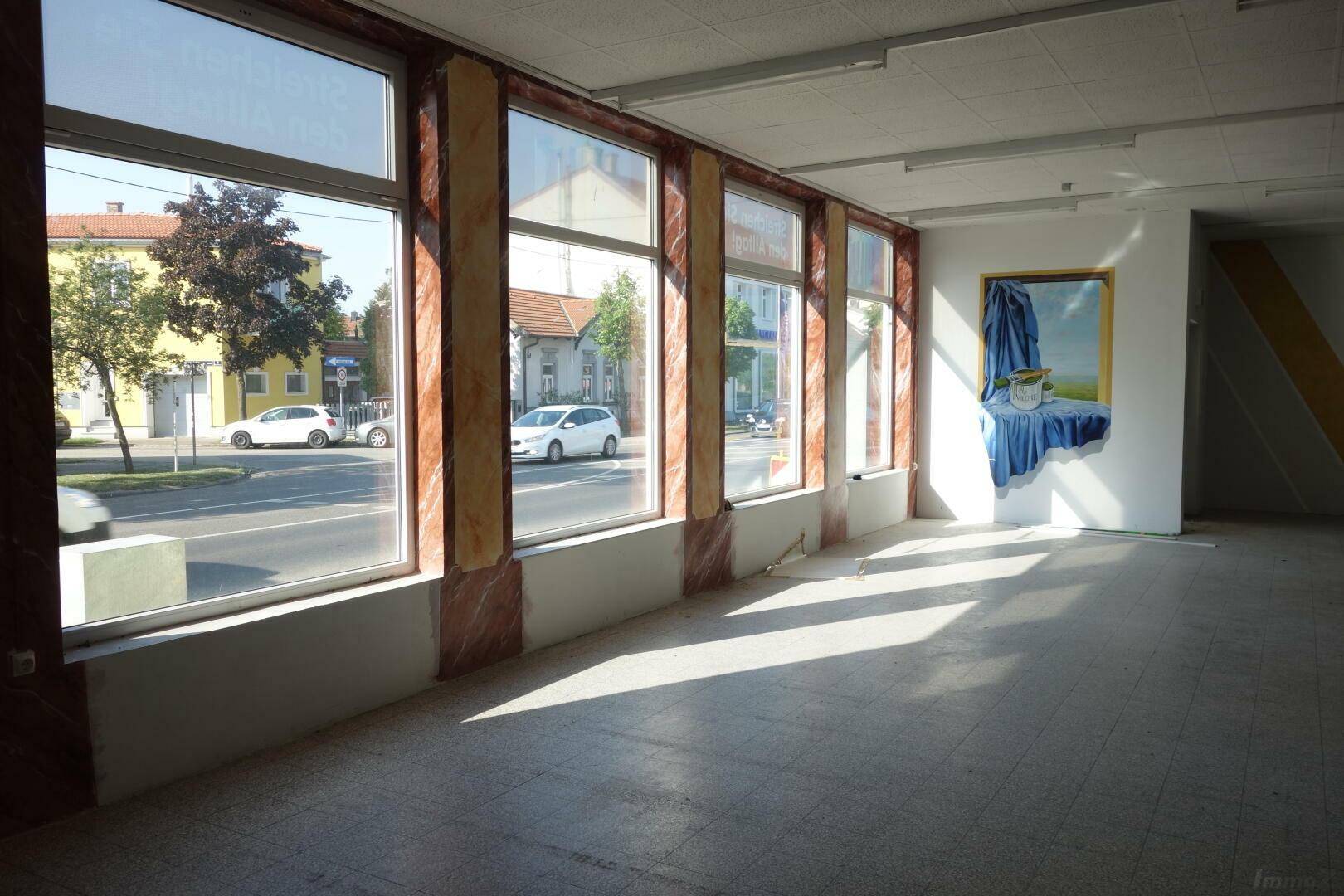 Heller Gewerberaum mit großen Schaufenstern zur Straße und viel Tageslicht.