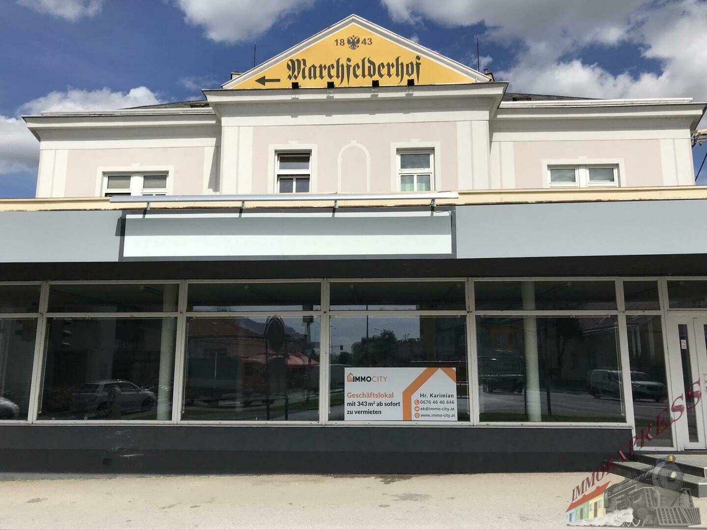 Die modernisierte Ladenfront des Geschäftsgebäudes mit großen Schaufenstern und einem "Zu vermieten"-Schild.