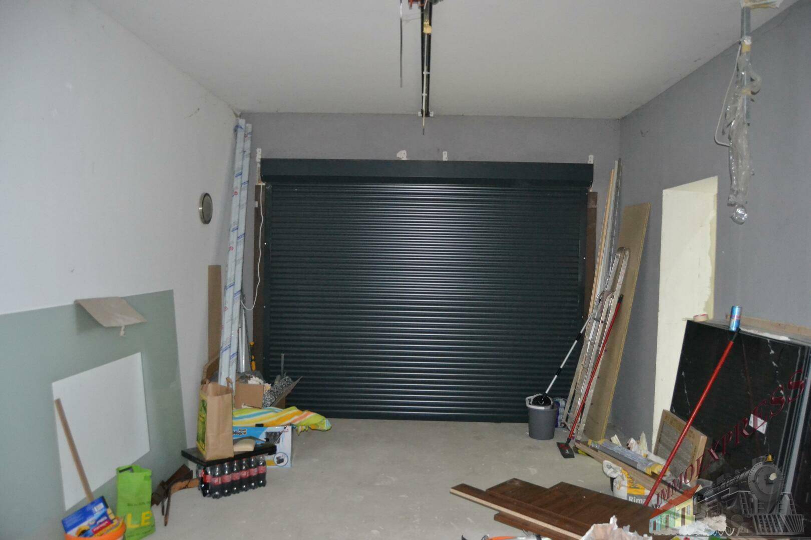 Geräumige Garage mit Rolltor und ausreichend Platz für Fahrzeuge und Lagerung.