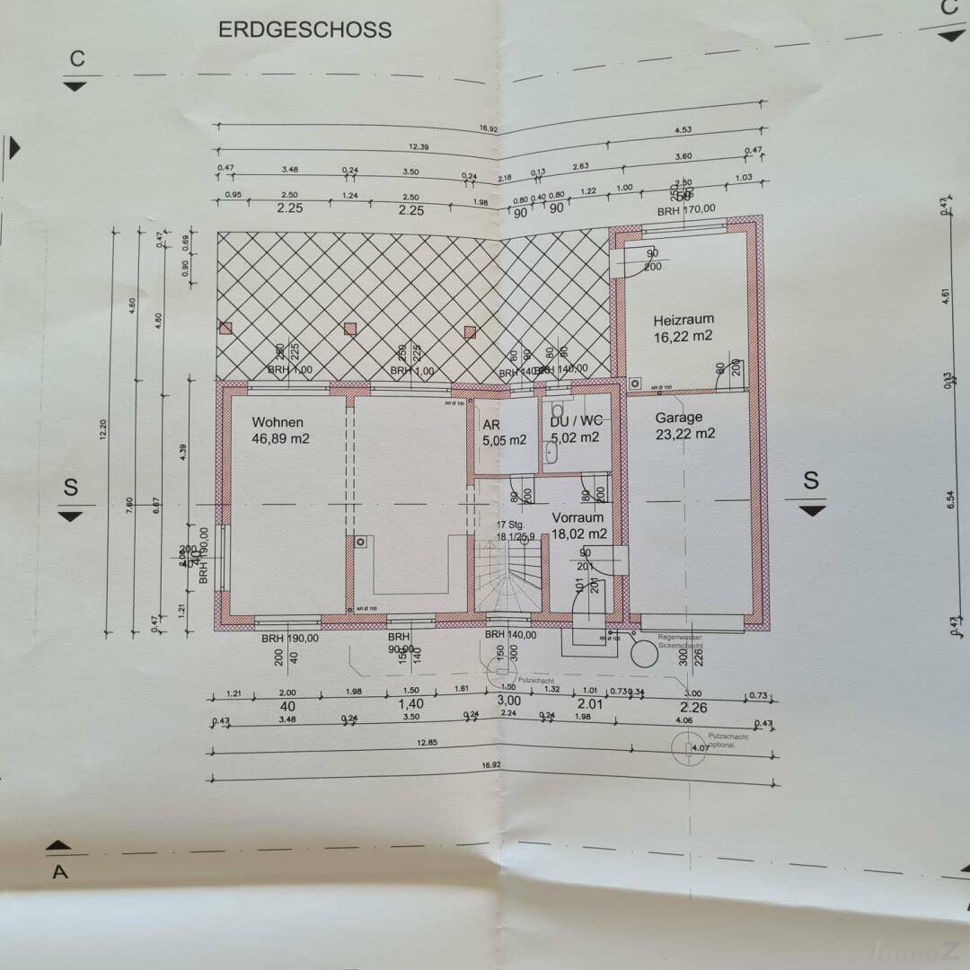 Grundriss des Erdgeschosses mit offenem Wohnbereich, Garage und Heizraum.