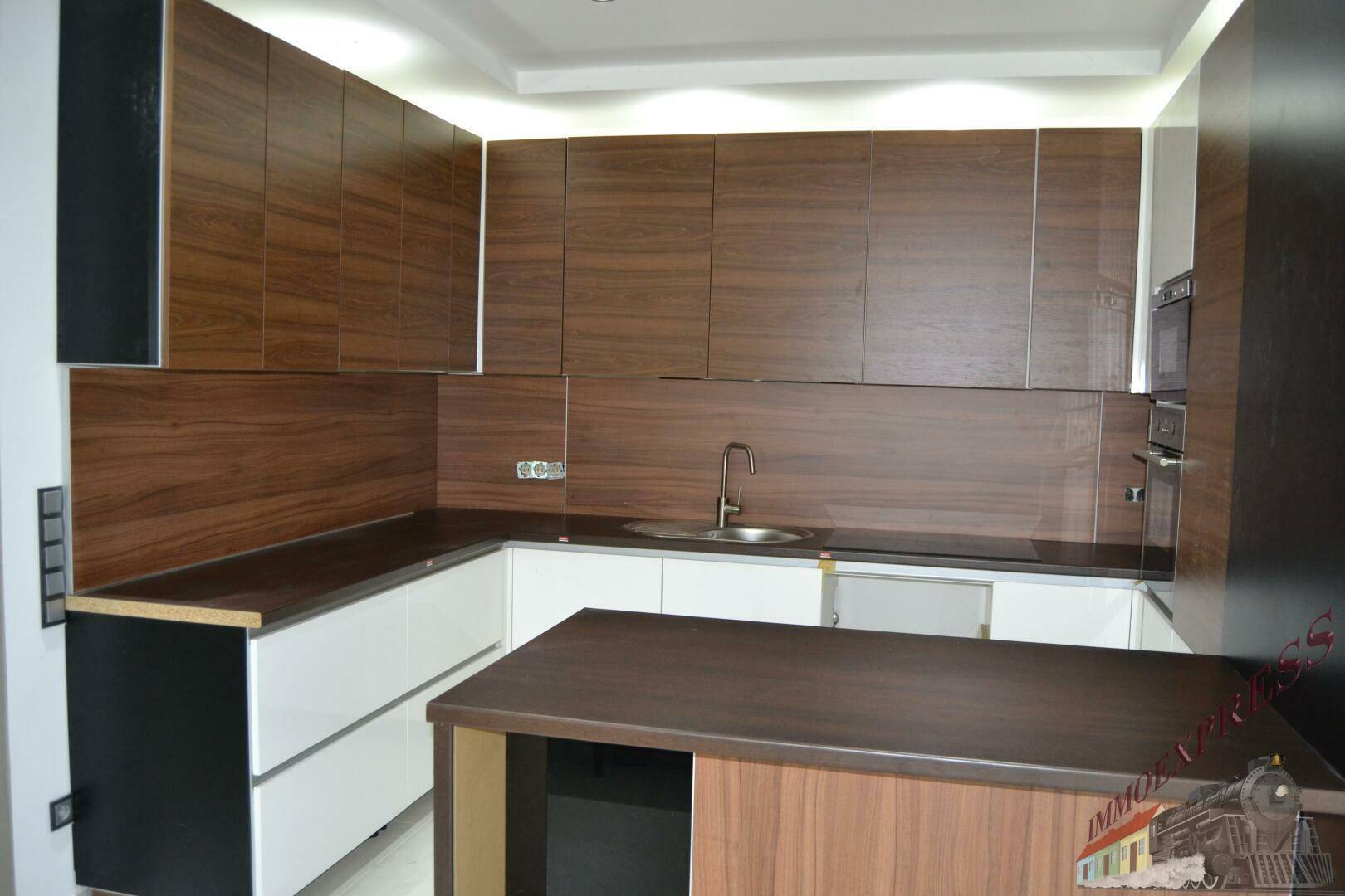 Moderne Einbauküche mit Holzfronten, weißen Unterschränken und dunkler Arbeitsplatte.