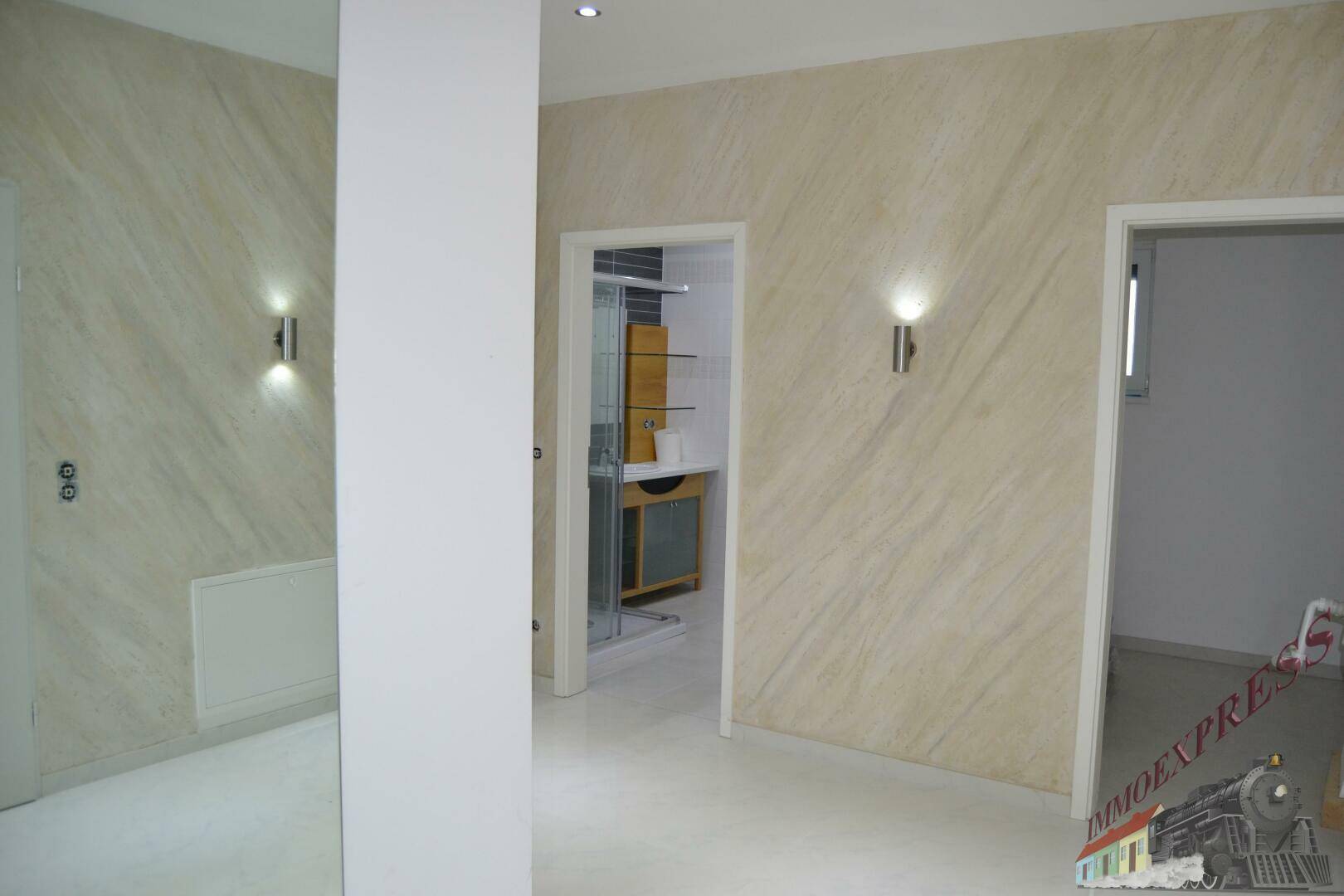 Flur mit strukturierten Wänden und Blick in ein angrenzendes Badezimmer oder Gäste-WC.