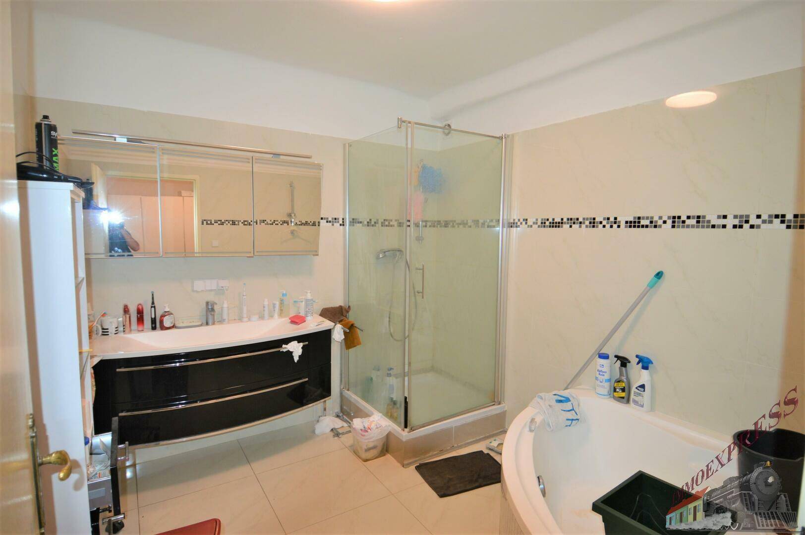 Geräumiges Badezimmer mit Duschkabine, Doppelwaschbecken und Eckbadewanne.