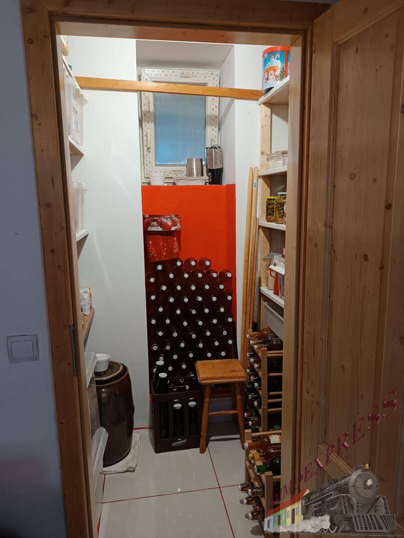 Gut organisierte Speisekammer mit Weinregalen, Vorräten und einem kleinen Fenster.
