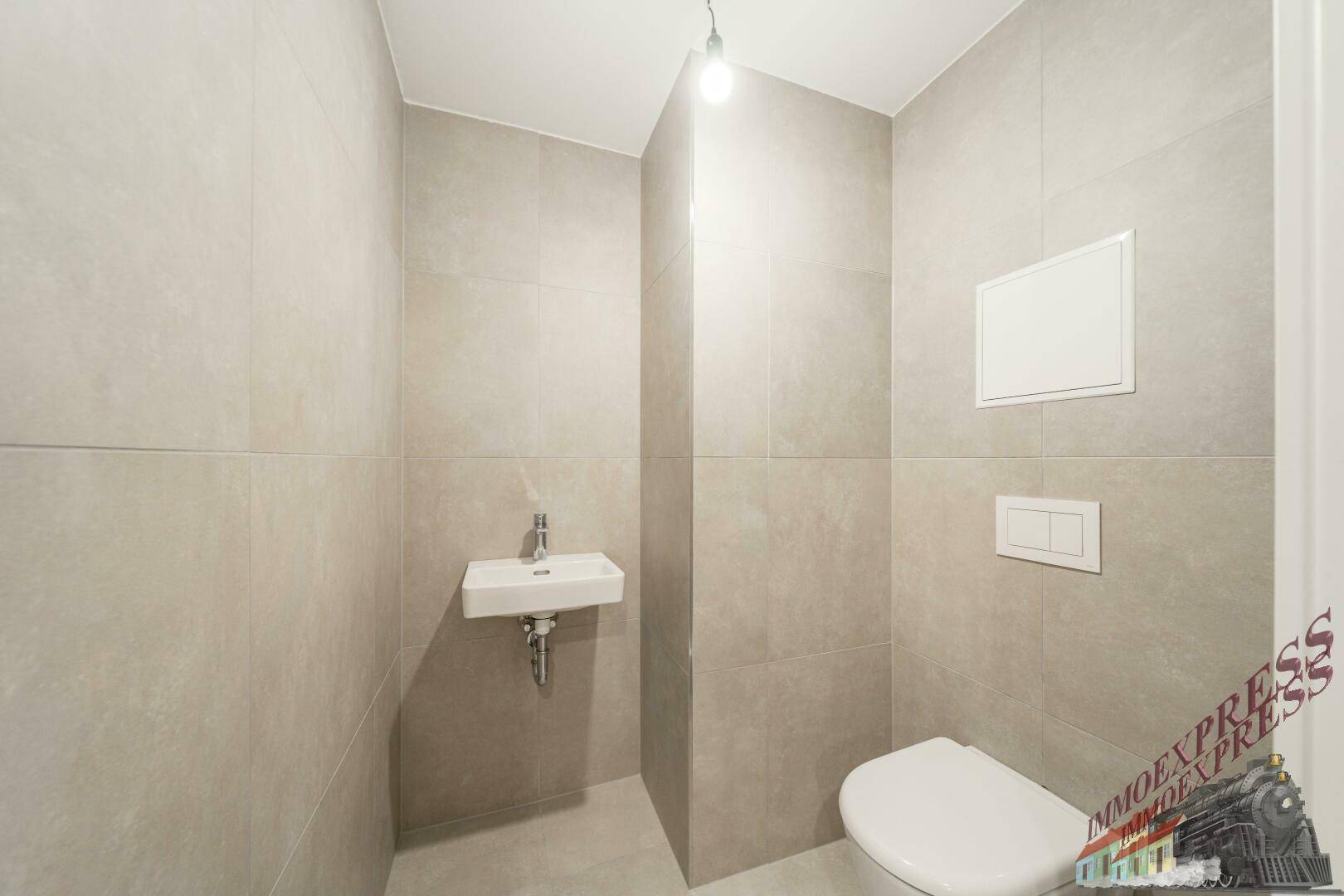 Modernes Gäste-WC mit Wand-WC und kleinem Waschbecken, hell gefliest.