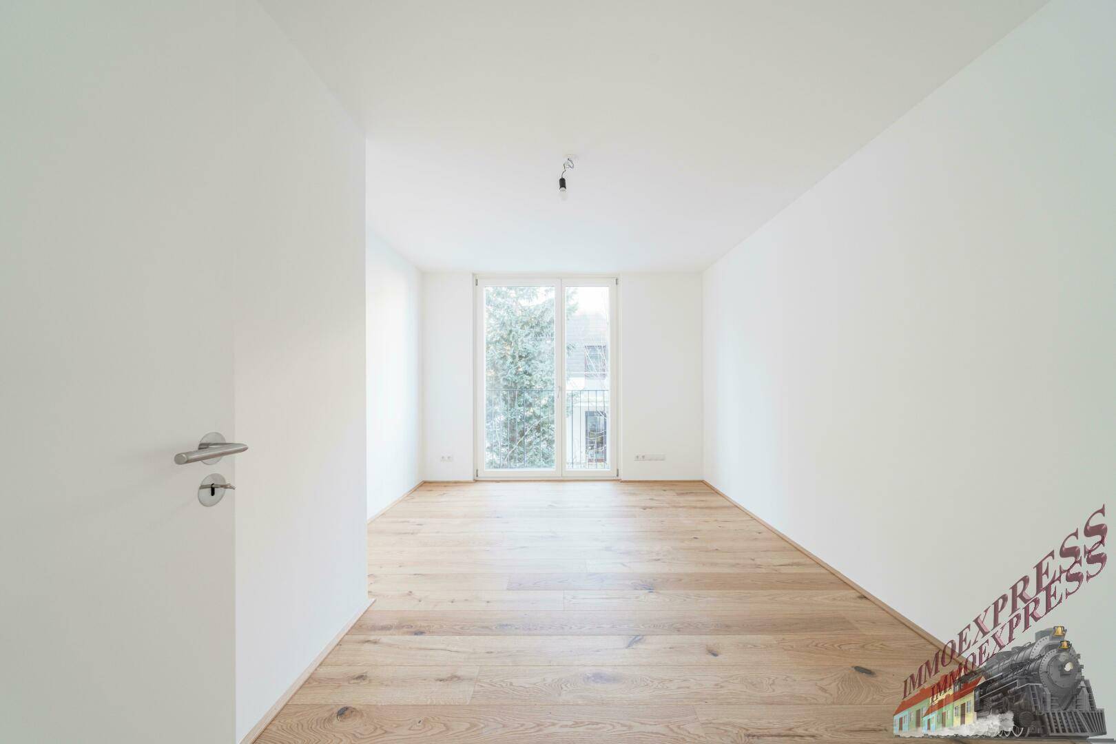 Leeres Zimmer mit Holzboden und Fenster, bereit zur individuellen Gestaltung.