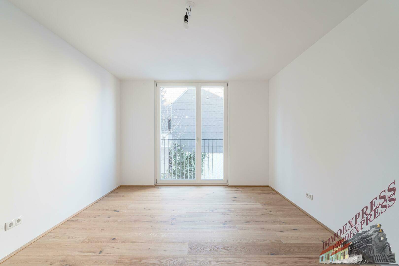 Helles Zimmer mit Holzboden und Fenster, ideal für Schlaf- oder Arbeitszimmer.