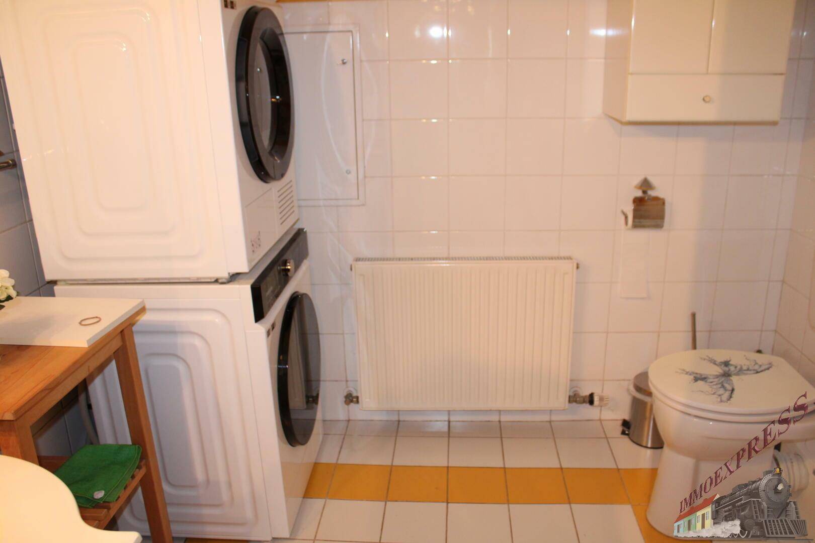 Hauswirtschaftsraum mit Waschmaschine, Trockner und Toilette, praktisch eingerichtet.