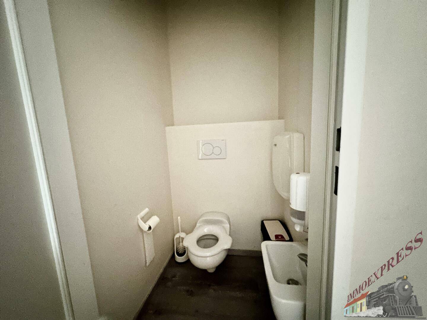 Kleine und funktionale Toilette mit wandhängendem WC und Handwaschbecken, in schlichtem Design.