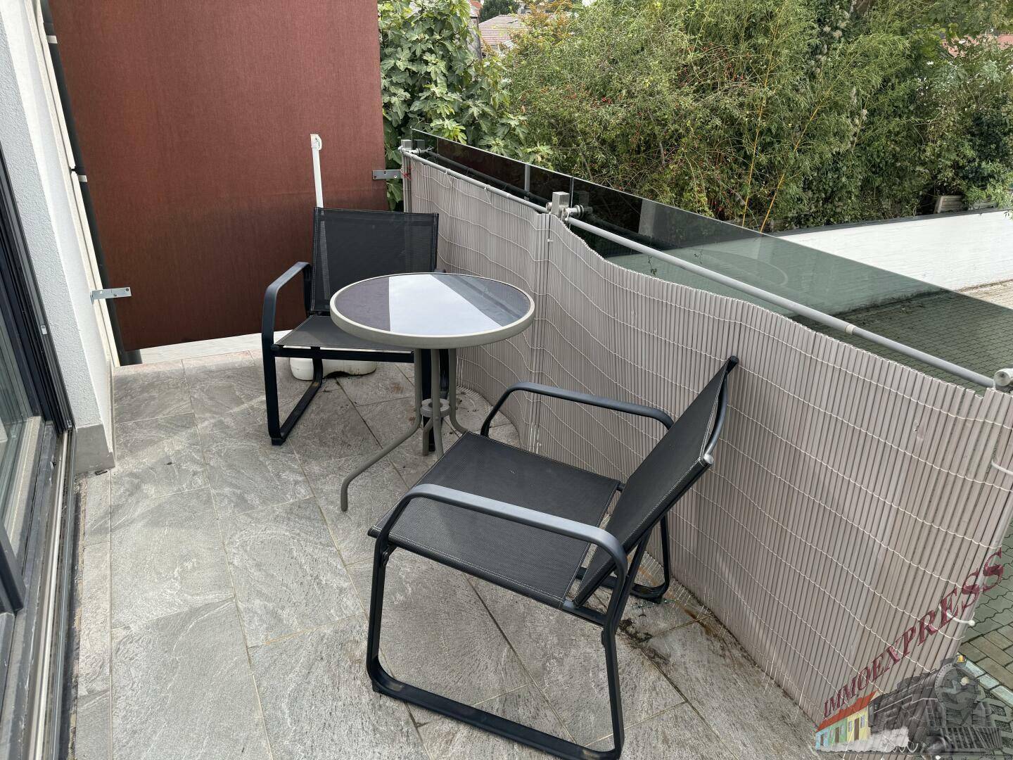 Gemütlicher Balkon mit Sitzgelegenheiten und Sichtschutz, ideal zum Entspannen.