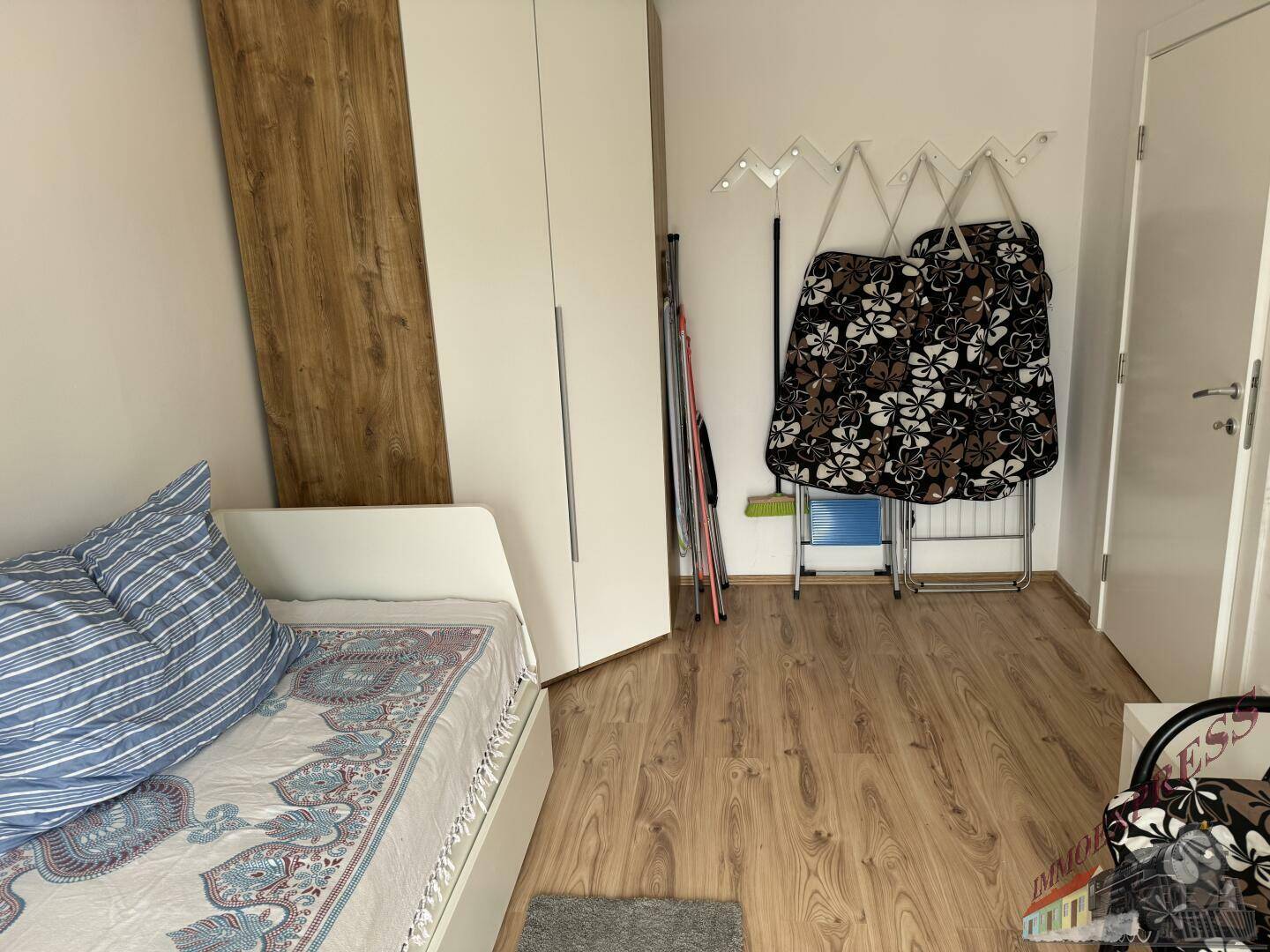 Schlafzimmer mit Einzelbett, Kleiderschrank und Holzboden, ideal als Gästezimmer.