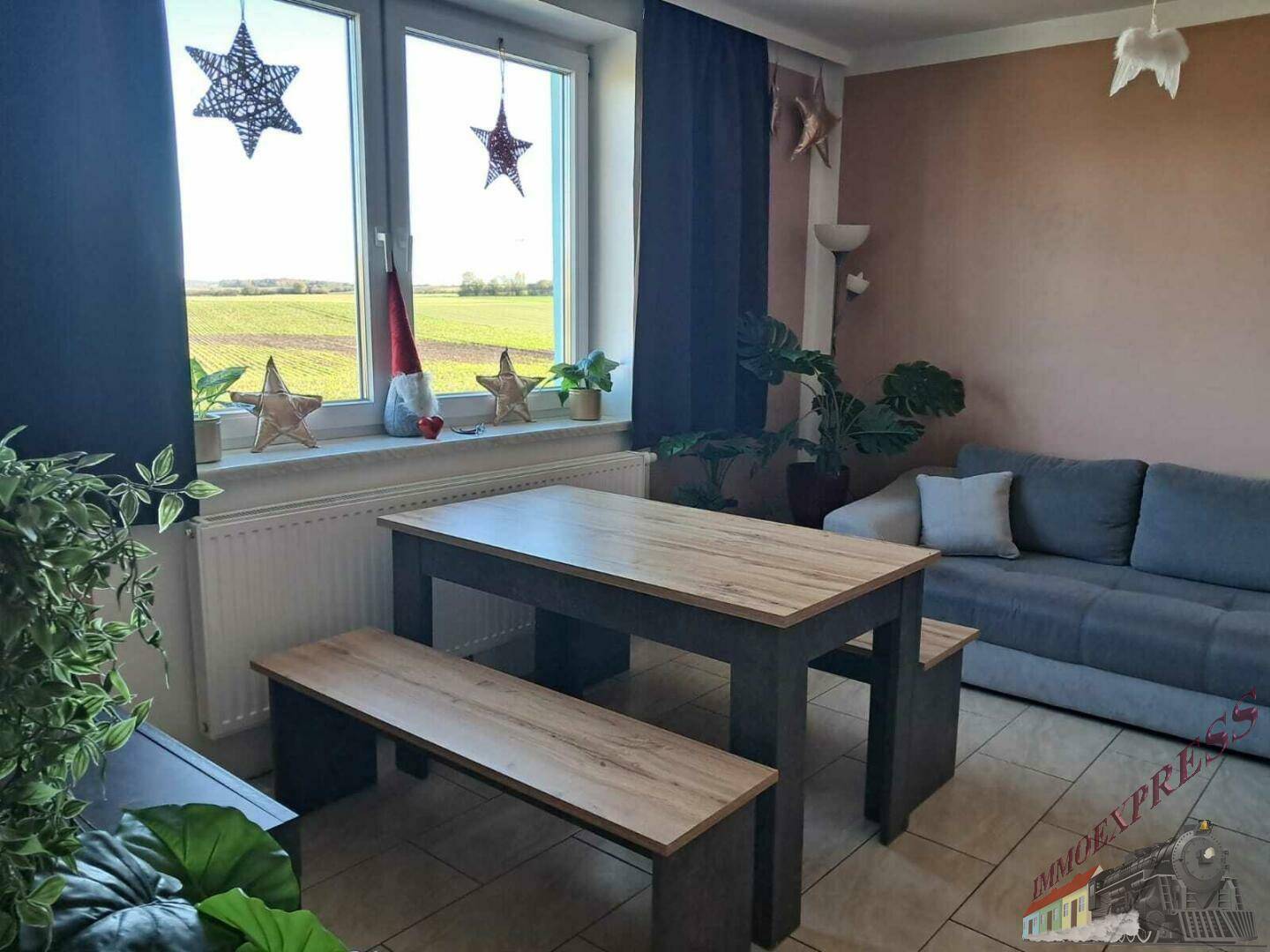 Der Wohn- und Essbereich bietet ein Sofa, einen Esstisch und einen schönen Blick ins Grüne.