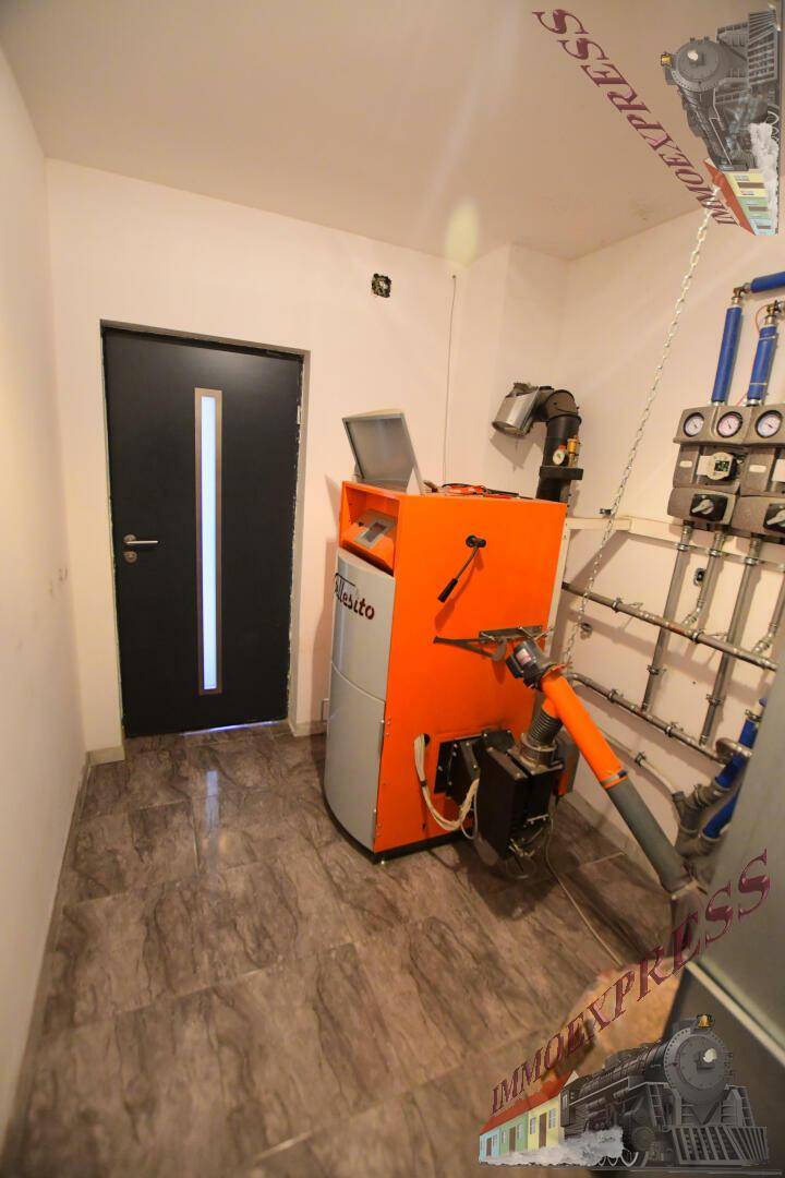 Technikraum mit Heizungsanlage und gefliestem Boden.