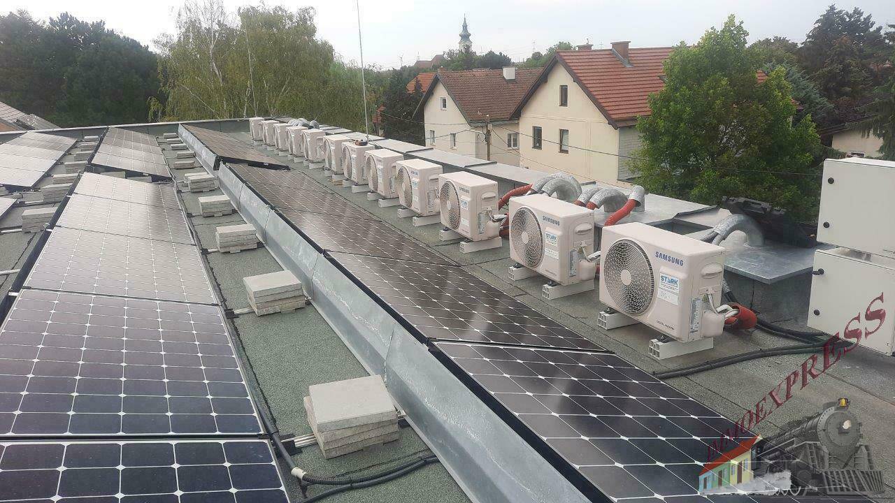 Dachfläche mit Solarpaneelen und einer Reihe von Klimaanlagen-Außengeräten.