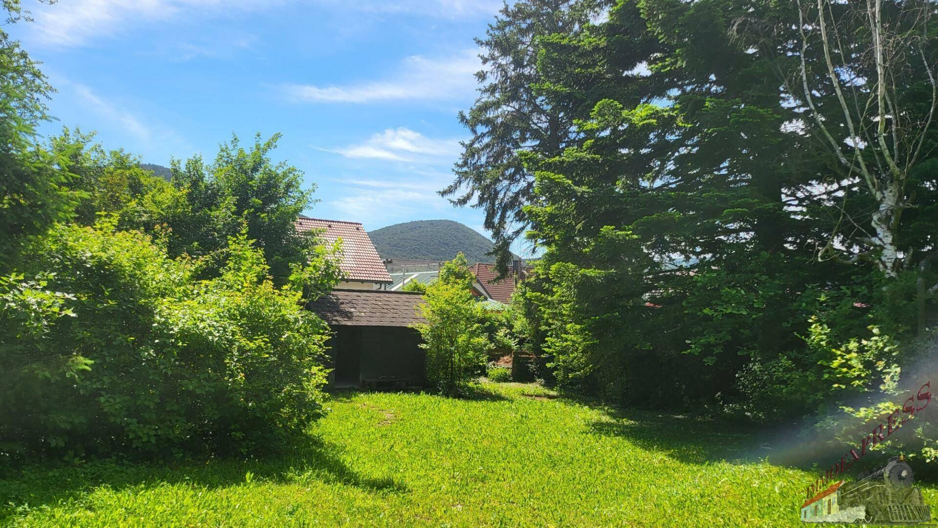 Großer Garten mit Rasenfläche und Fernblick auf die umliegende Hügellandschaft.