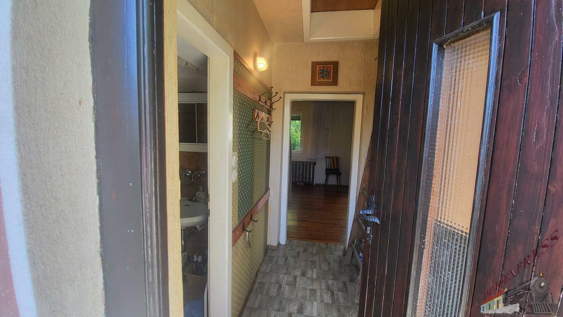Eingangsbereich mit gemustertem Boden, Garderobe und Zugang zu weiteren Räumen.