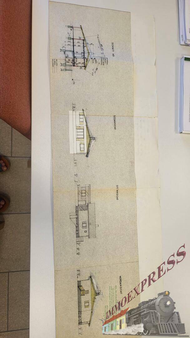 Verschiedene Ansichten des Gebäudes aus einem Bauplan, inklusive Schnitten und Fassaden.