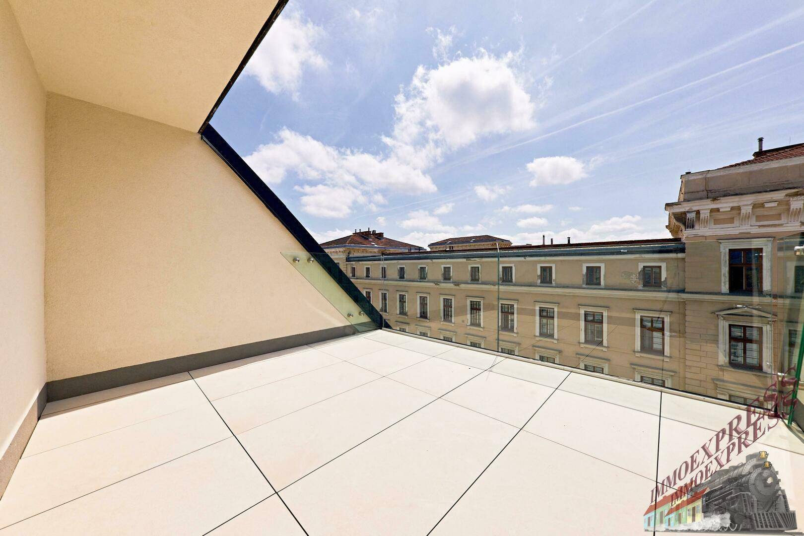 Moderne Terrasse mit Fliesenboden und Glasgeländer, bietet einen schönen Blick auf die Stadt.