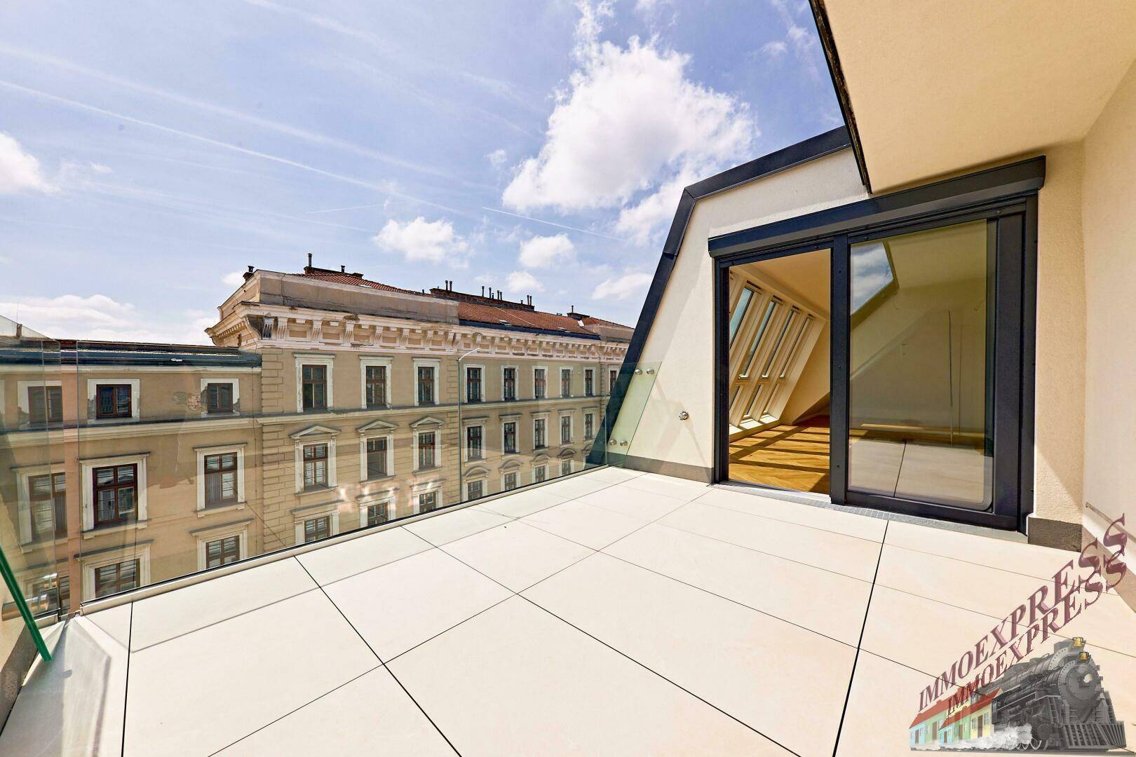 Moderne Terrasse mit Fliesenboden und Glasgeländer, bietet einen schönen Blick auf die Stadt.