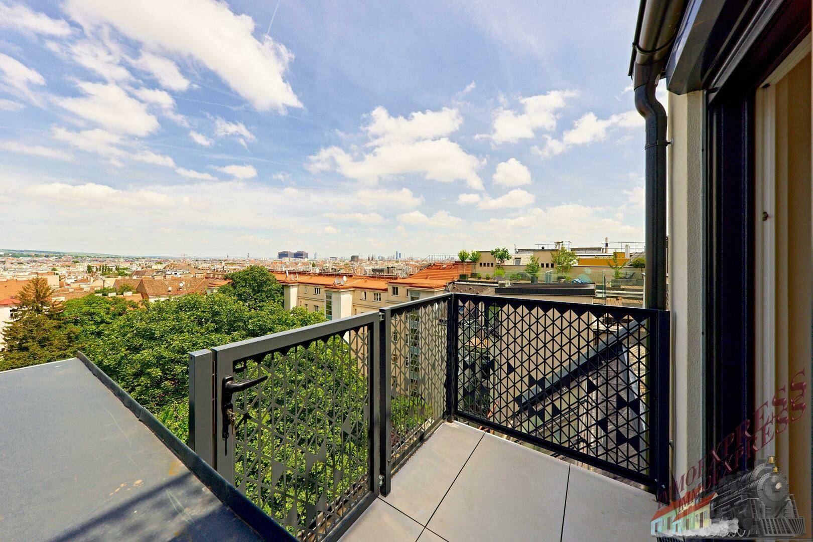 Kleiner Balkon mit moderner Brüstung und Blick auf die Stadtlandschaft.