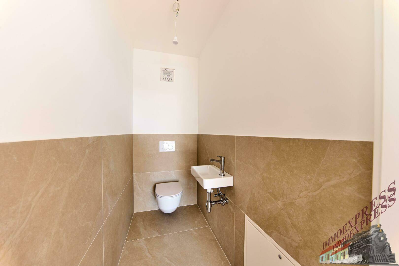 Modernes Gäste-WC mit Wand-WC, kleinem Waschbecken und beigefarbenen Fliesen.