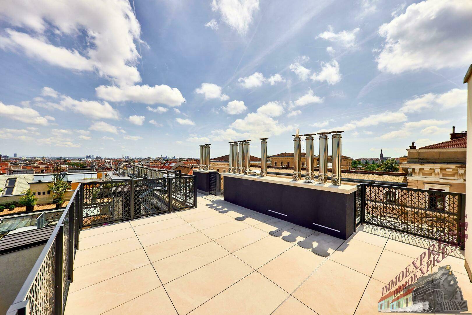 Dachterrasse mit modernen Kaminen und weitem Blick über die Stadtlandschaft.