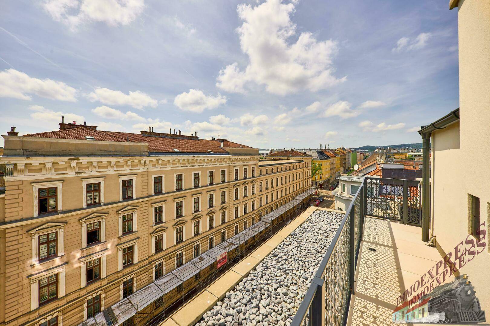 Blick von einem Balkon auf die gegenüberliegende historische Fassade und die Stadt.