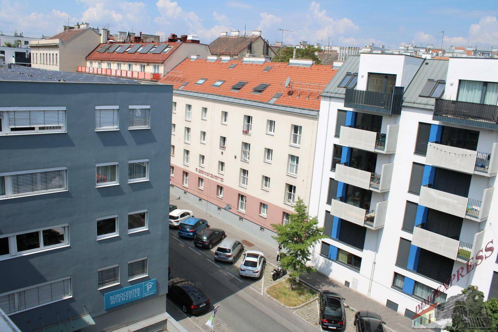 Stadtansicht mit verschiedenen Wohngebäuden und einer belebten Straße darunter.