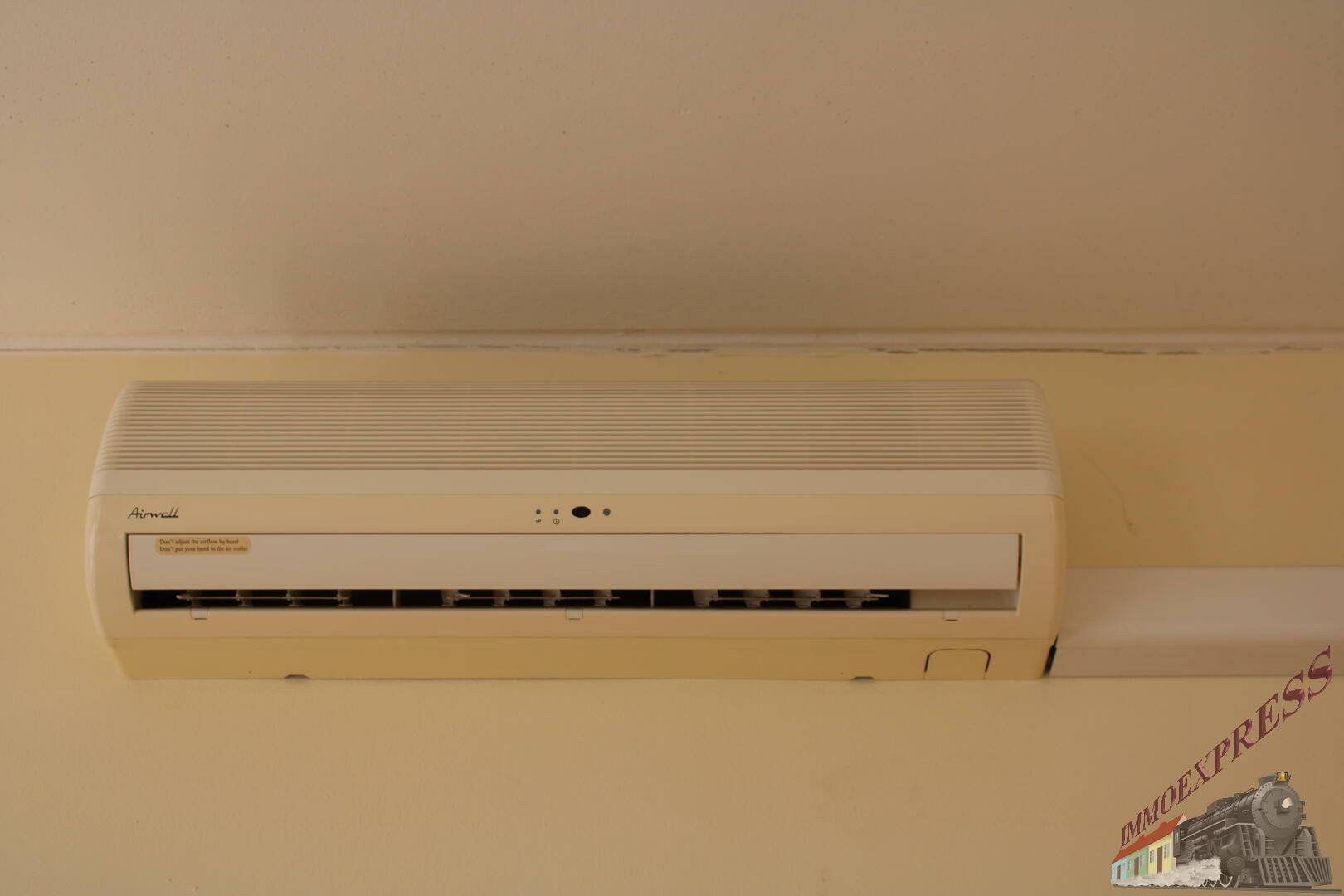 Nahaufnahme einer Klimaanlage an der Wand, die für angenehme Raumtemperaturen sorgt.