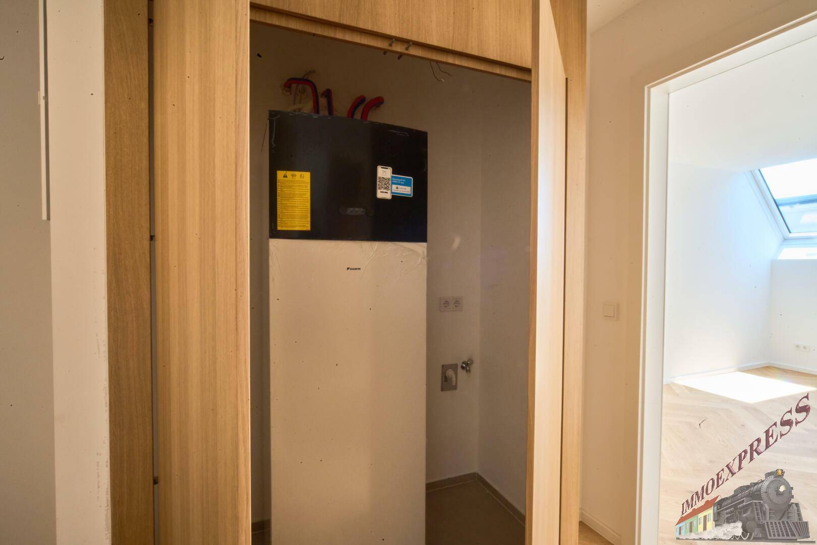 Kleiner Abstellraum mit Warmwasserbereiter und Holzvertäfelung, praktisch und funktional.