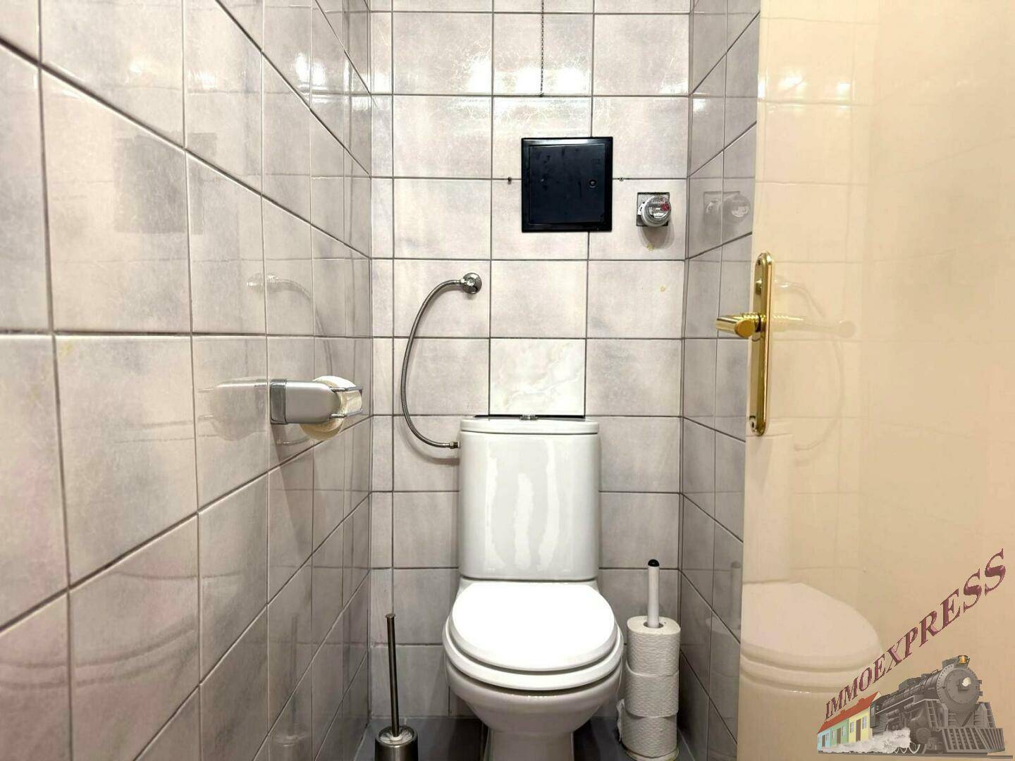 Kleines WC mit hellen Fliesen und wandmontierter Toilette, funktional und sauber.