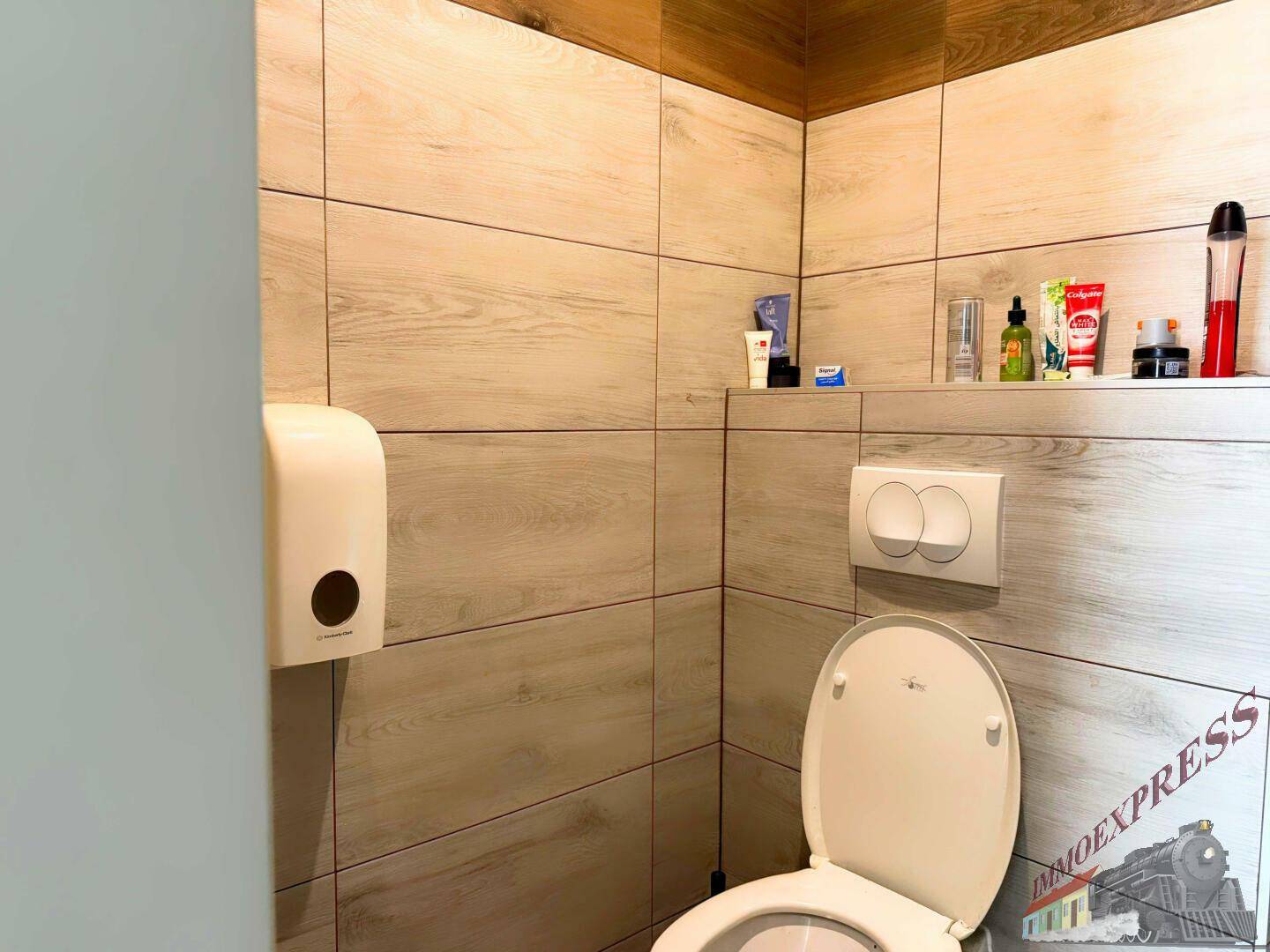 Saubere Toilette mit modernen Fliesen in Holzoptik und einem Wand-WC, das Funktionalität bietet.
