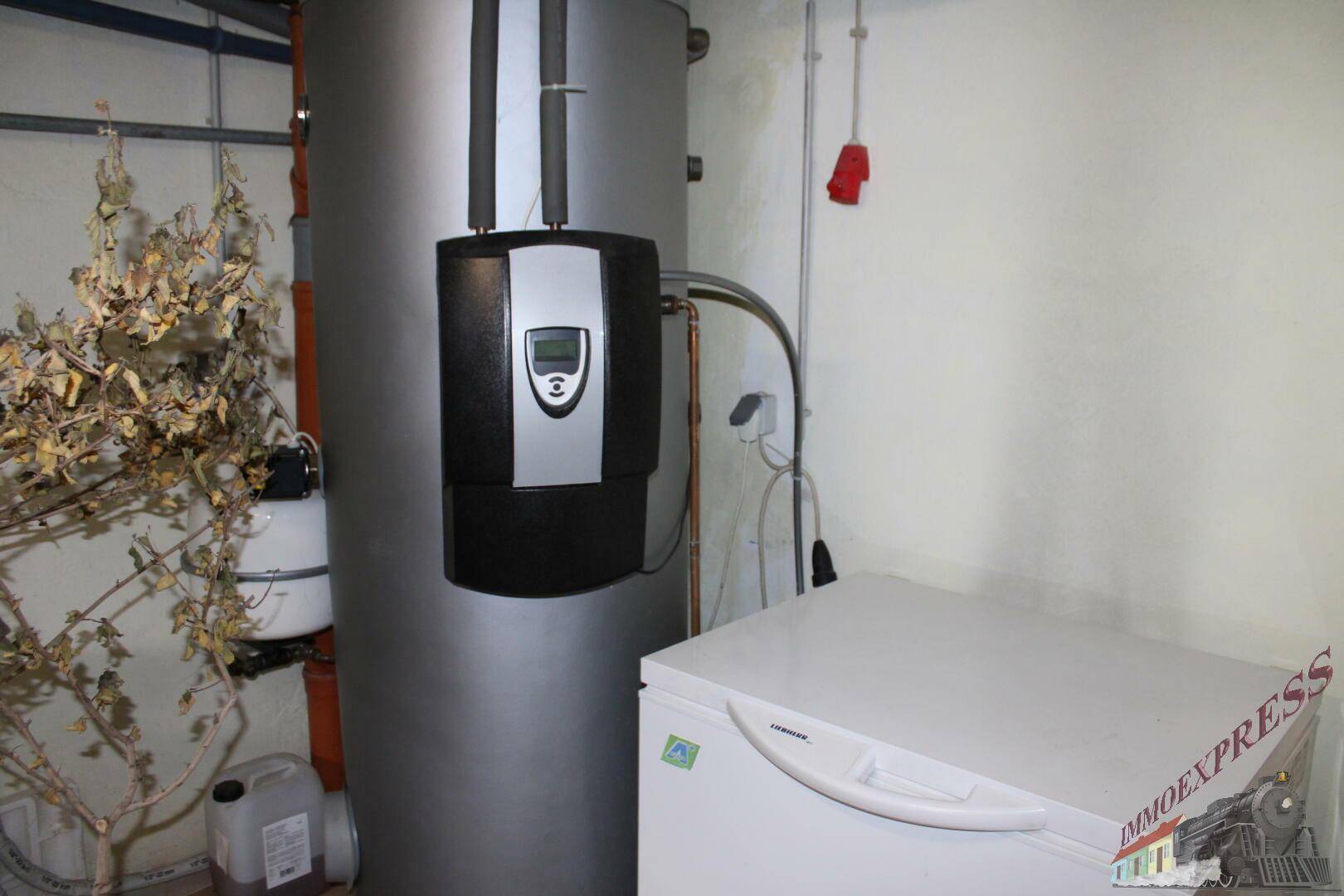 Heizungsraum im Keller mit Warmwasserspeicher und Gefrierschrank.