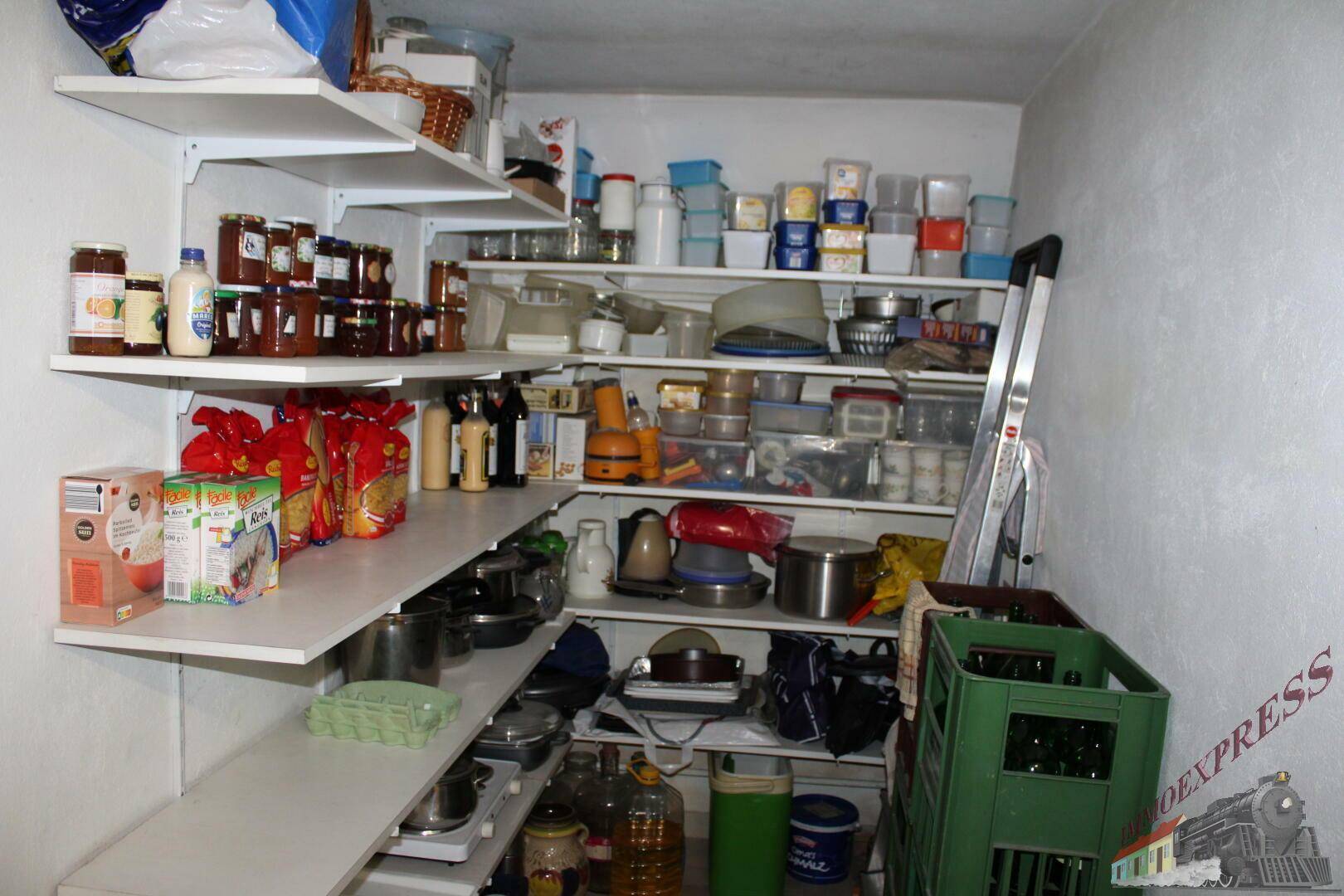 Gut gefüllte Speisekammer im Keller mit vielen Regalen für Vorräte.