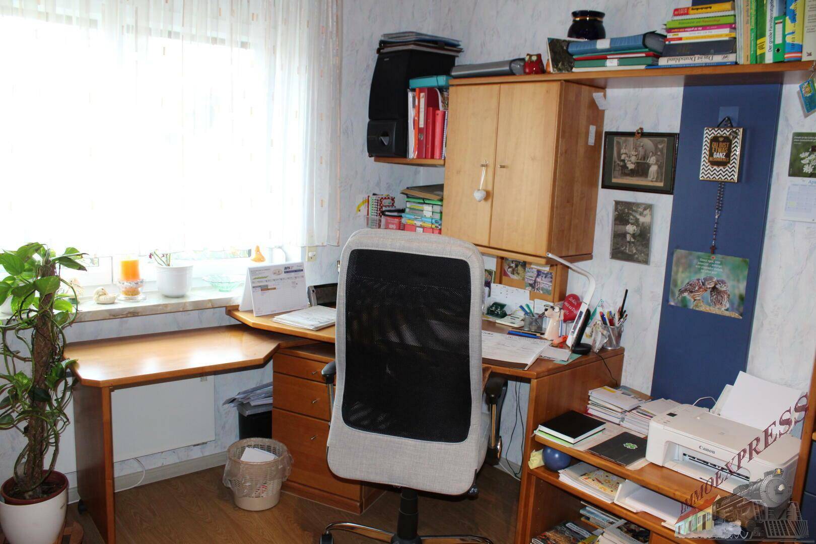 Arbeitsbereich mit Schreibtisch, Bürostuhl und Fenster für natürliches Licht.