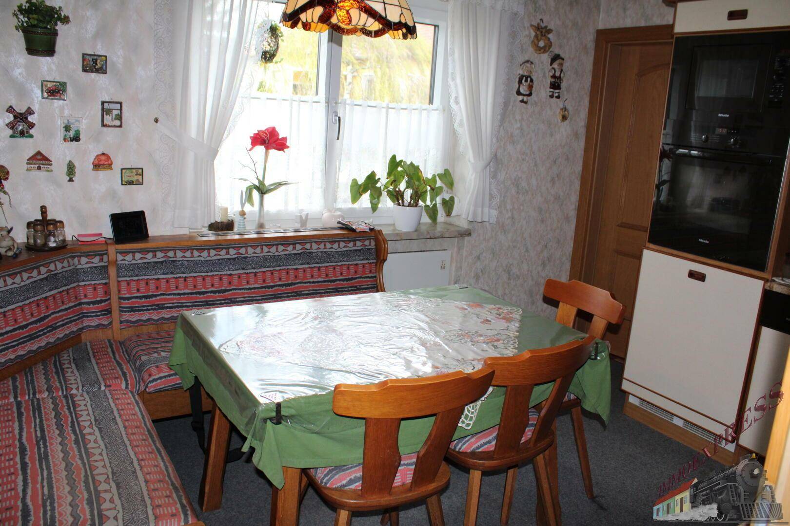 Gemütliche Wohnküche mit Eckbank, Esstisch und Fenster für Tageslicht.