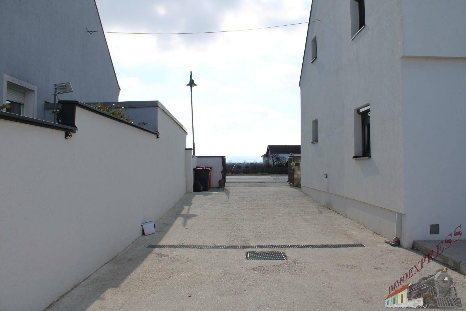 Zufahrtsweg zwischen zwei Gebäuden mit Blick in die Ferne.
