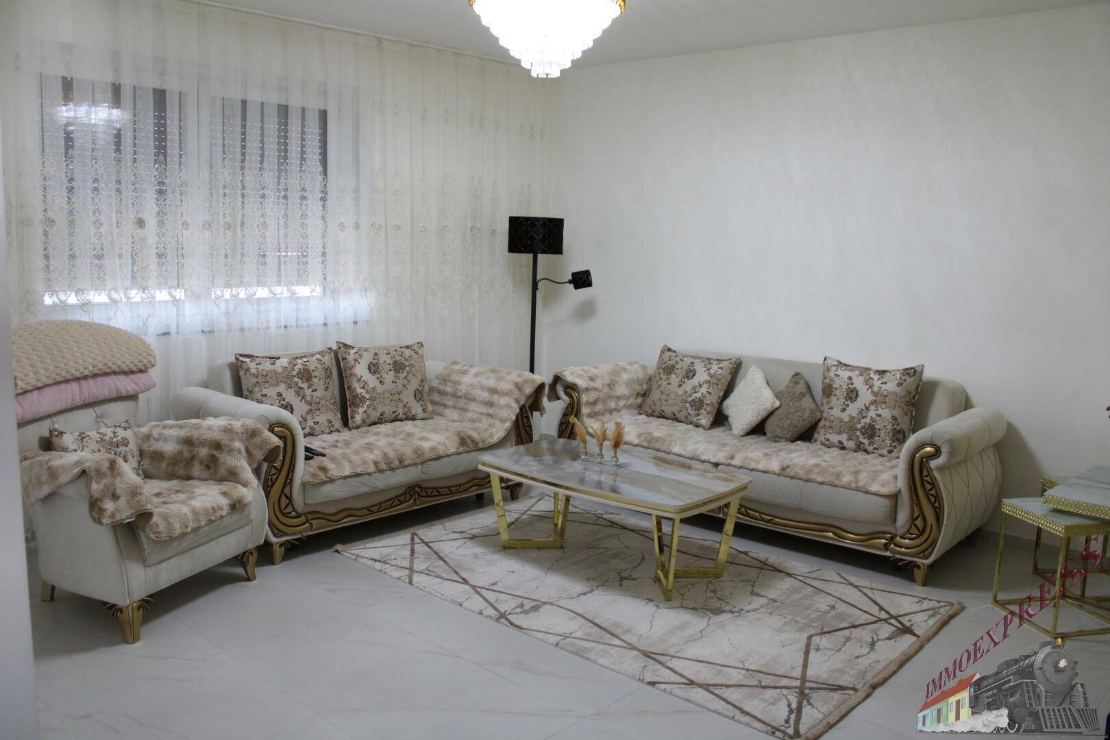 Helles Wohnzimmer mit eleganten Sofas, Teppich und modernem Couchtisch.