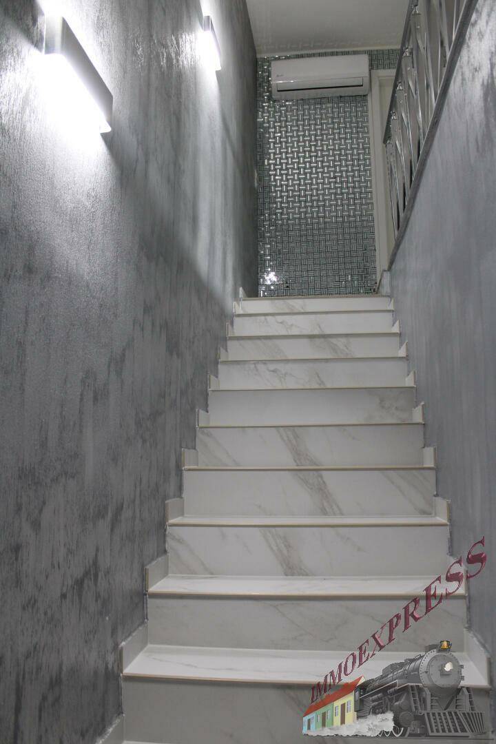 Treppenhaus mit gefliesten Stufen und moderner Wandverkleidung.