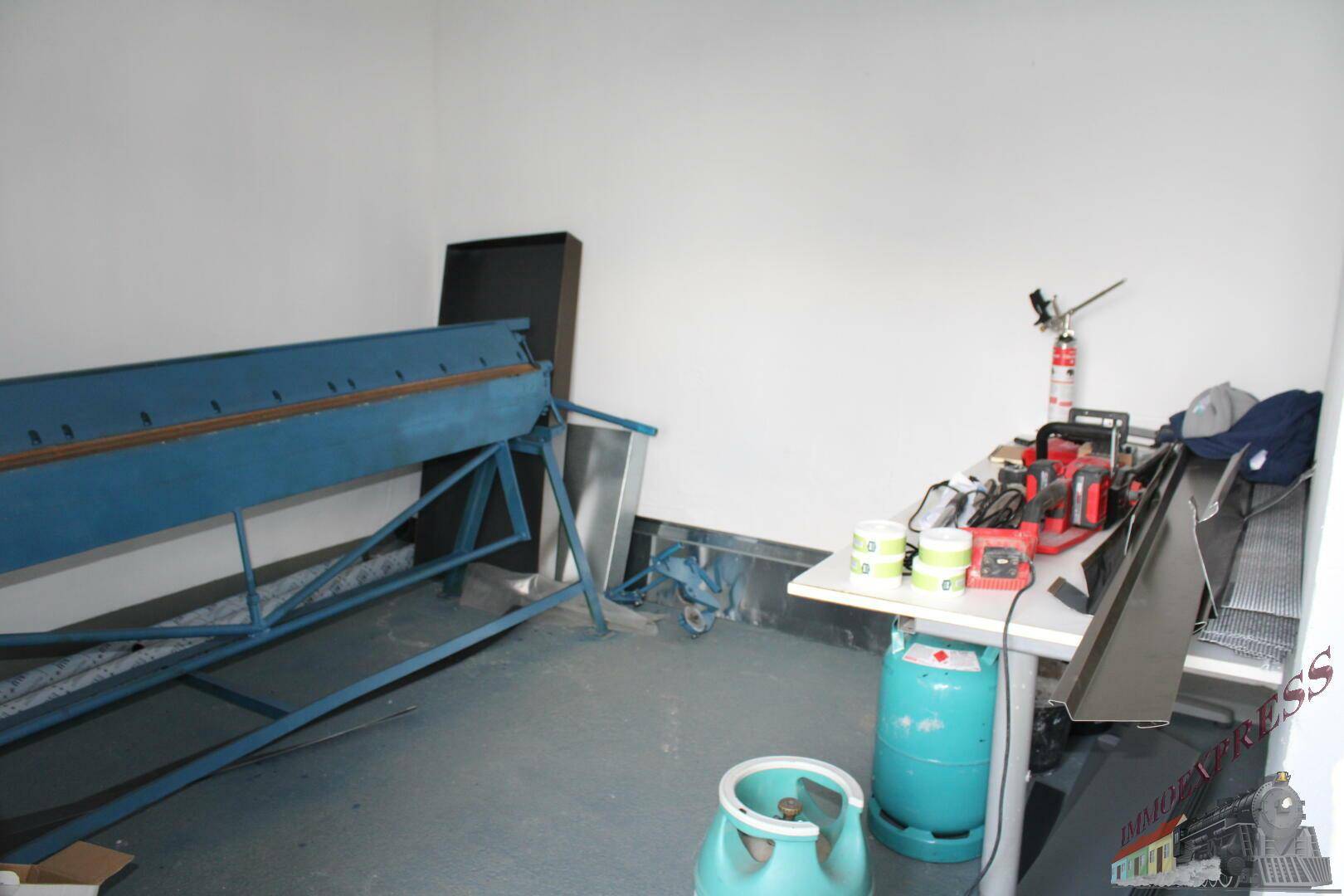 Werkstattraum mit Metallbearbeitungsmaschine und Gasflaschen.