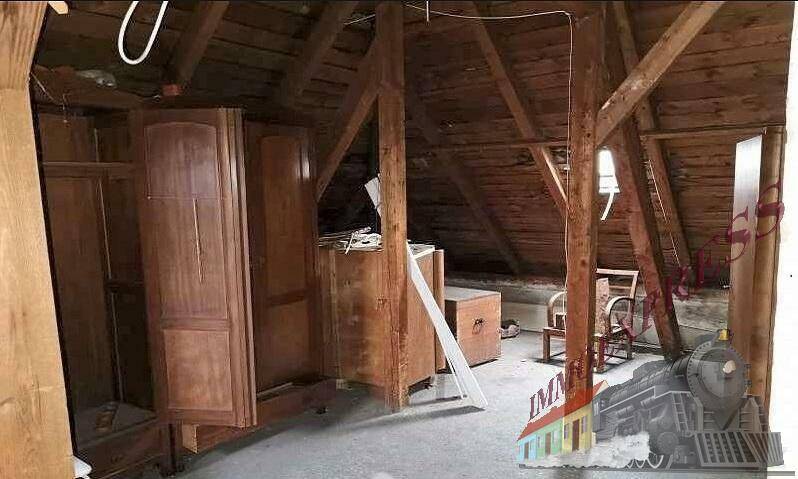 Dachboden mit sichtbaren Holzbalken und gelagerten Möbeln, bietet Stauraum oder Ausbaupotenzial.