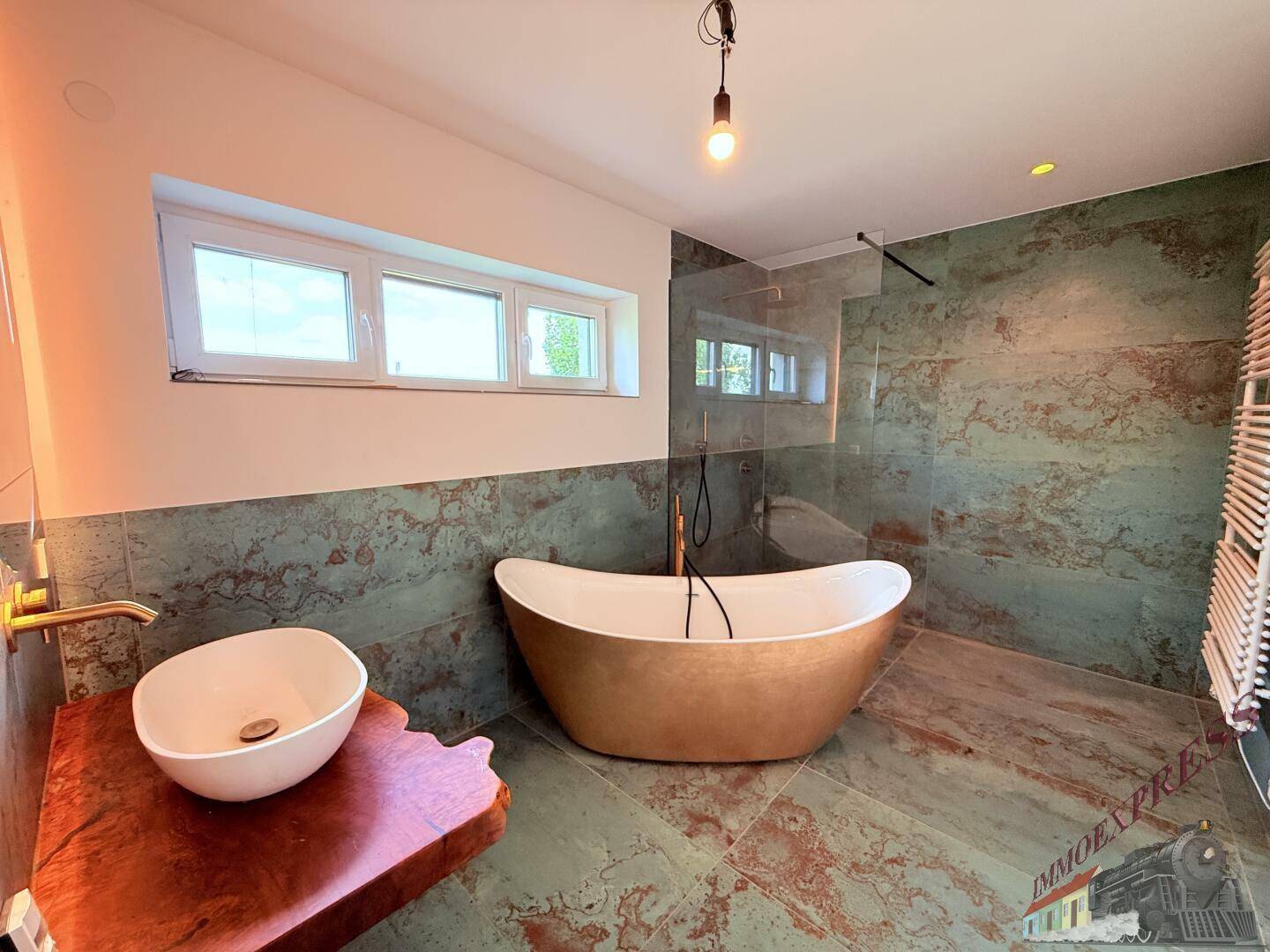 Modernes Badezimmer mit freistehender Badewanne, großer Dusche und auffälligen Wand- und Bodenfliesen.