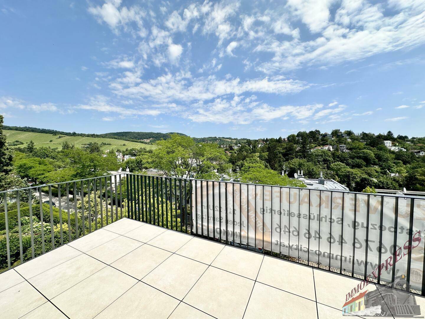 Weitläufige Terrasse mit Fliesenboden und Panoramablick über die Landschaft.